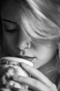grayscale photo of woman holding mug thumbnail