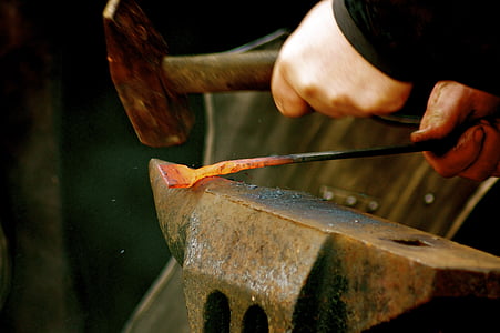 person welding a metal with hammer on anvil thumbnail