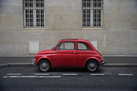 classic red coupe parked on gray concrete road thumbnail