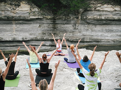 women doing yoga on rock formation thumbnail