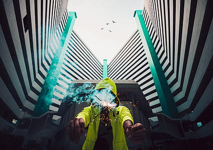 person holding firecracker near white high-rise building thumbnail