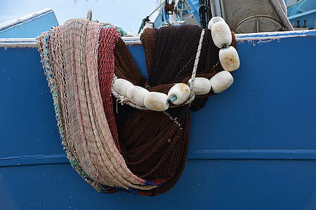 brown and red fishnet hanging on blue panel thumbnail