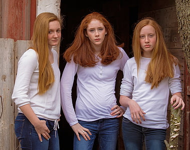 three woman wearing white long-sleeved shirts standing beside wooden wall thumbnail