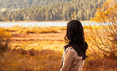 woman in beige jacket standing in front of mountain thumbnail