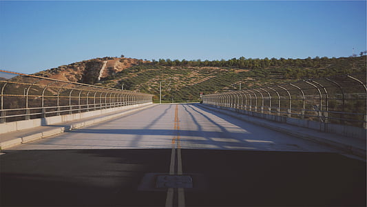 gray concrete fronting green hill thumbnail