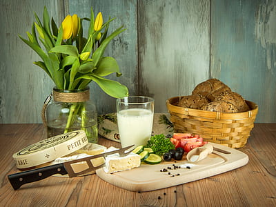 sliced vegetables on chopping board with knife beside glass of milk and basket thumbnail