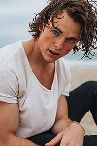 focus photo of man in white scoop-neck t-shirt thumbnail