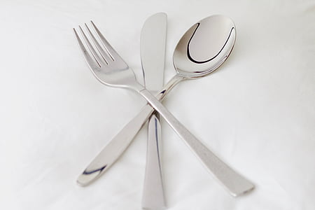 silver spoon, fork, and table knife on white cloth thumbnail