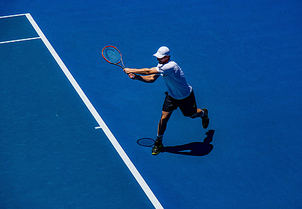 man in white shirt and black shorts playing tennis thumbnail