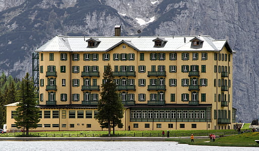 yellow and gray building near hills thumbnail