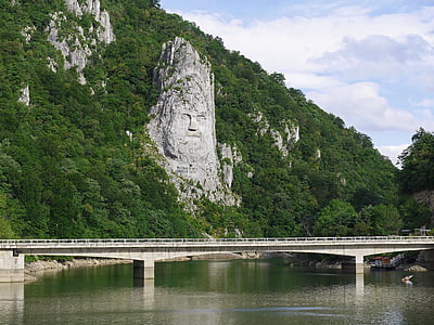 landscape photo of bridge and mountain range during daytime thumbnail