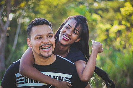 selective focus photo of man carrying woman at his back thumbnail