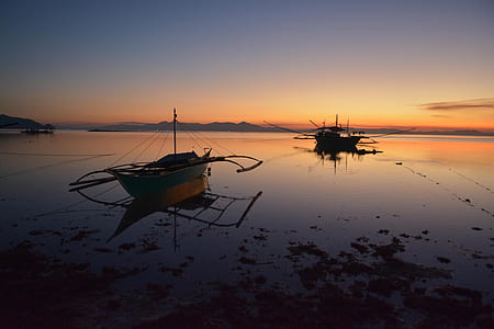 boat on body of water at sunset thumbnail