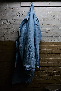 blue apparel hanging on grey and brown wall inside room thumbnail