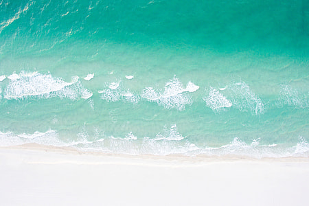 Aerial drone shot of a sandy beach and ocean in the summer thumbnail