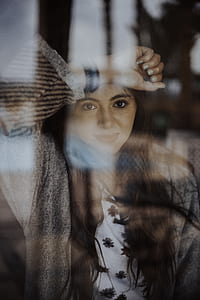 person raising right arm while looking on glass thumbnail