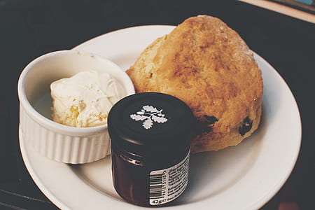 baked bread with cake and jam bottle on top of ceramic plate thumbnail