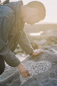 Man Sketching Heart on a Gray Rock thumbnail