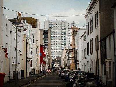 black vehicles parked outside white buildings at daytime thumbnail