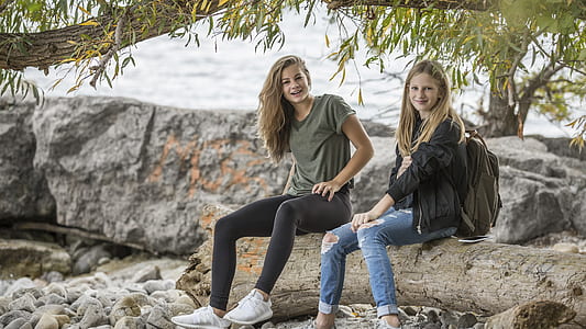 2 Women Sitting on Rock during Daytime thumbnail