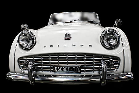 white Triumph car against black background thumbnail