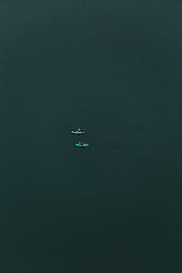 aerial photography of two blue boats in middle of body of water thumbnail