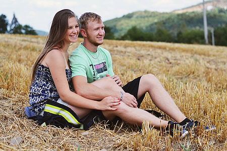 man and woman sitting on brown grass on top of mountain thumbnail