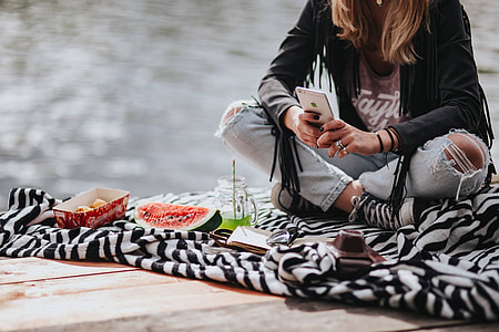 Blonde woman having a healthy snack at the wooden pier thumbnail