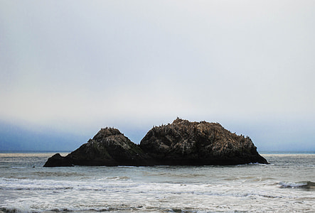 brown rock surrounded by body of water thumbnail