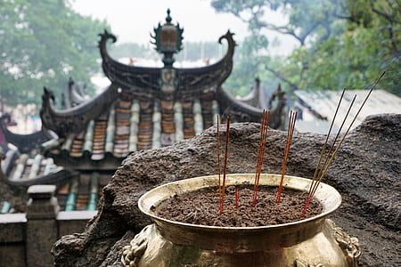 brass-colored pot with incense candles on focus photo thumbnail