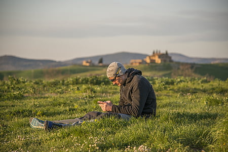 man sitting on grass field thumbnail