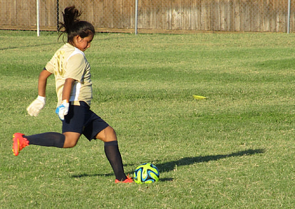woman about to kick green ball on field thumbnail