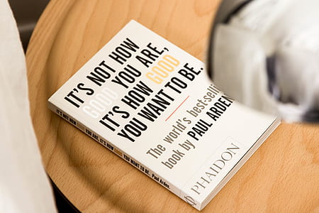 It's Not How Good You Are, It's How Good You Want To Be by Paul Arden book on brown wooden surface thumbnail