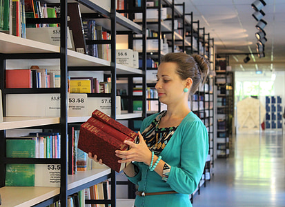 woman wearing teal top holding books thumbnail
