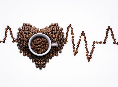 coffee beans formed in shape of heart beat with white ceramic mug thumbnail