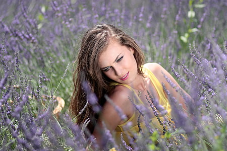 selective focus photography of woman surrounded by flowers thumbnail