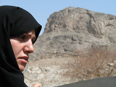 woman in front of brown rock formation thumbnail