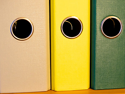 brown, yellow, and green binders on brown wooden surface thumbnail