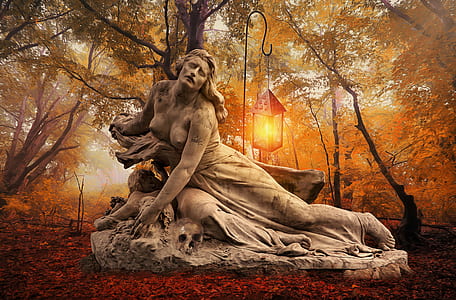 selective photo of woman concrete statue under brown trees thumbnail