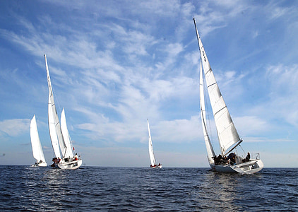 four white sail boats on body of water thumbnail