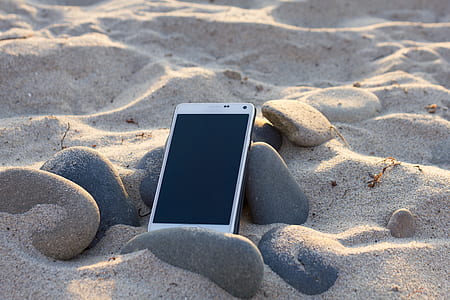 smartphone on black stone and sand thumbnail
