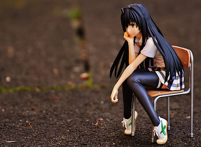 black haired woman figurine sitting on chair miniature thumbnail