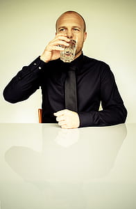 man drinking using his right hand while sitting thumbnail