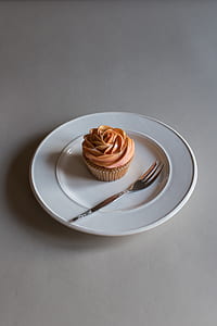 cupcake beside gray steel fork on white ceramic plate thumbnail