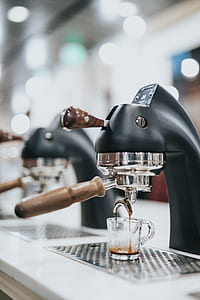 clear glass cup under black espresso machine thumbnail