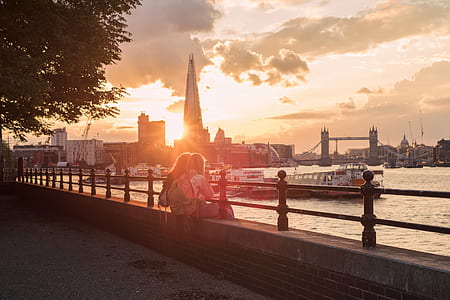 two person sitting on concrete wall during daytime thumbnail