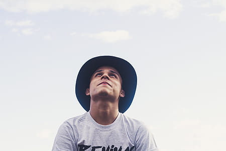 man wearing white crew-neck shirt and black cap thumbnail