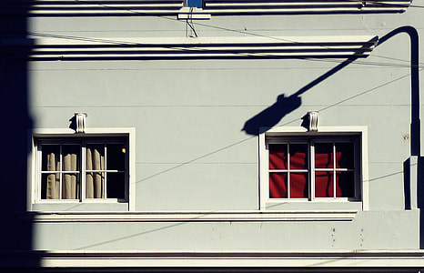 blue and white painted concrete house with shadow of streetlight photo during day time thumbnail