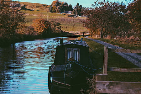 black boat floating in body of water beside a dock thumbnail
