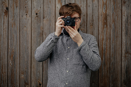man in  gray coat jacket a holding an DSLR camera thumbnail